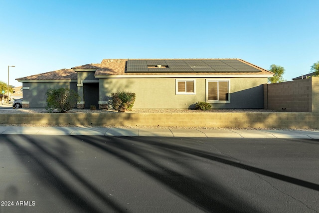 view of front of property featuring solar panels