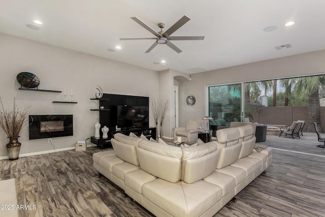 4519 N 29th Way, Phoenix, AZ 85016 - living room with wood finished floors, arched walkways, ceiling fan, recessed lighting, and a glass covered fireplace