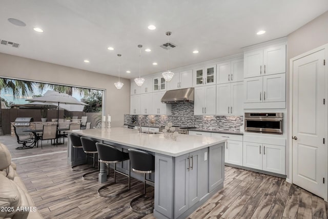 4519 N 29th Way, Phoenix, AZ 85016 - kitchen featuring under cabinet range hood, stainless steel oven, tasteful backsplash, recessed lighting, and gray cabinetry