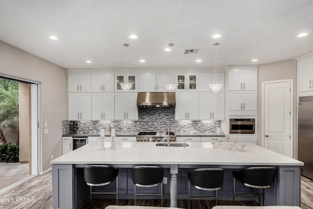 4519 N 29th Way, Phoenix, AZ 85016 - kitchen with under cabinet range hood, a sink, appliances with stainless steel finishes, light wood finished floors, and a large island