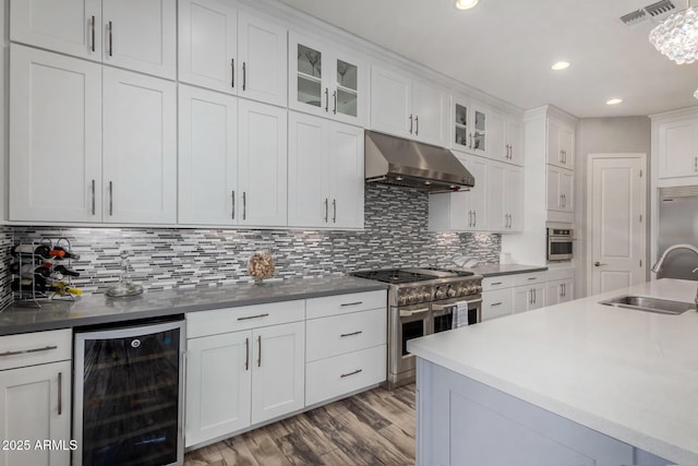 4519 N 29th Way, Phoenix, AZ 85016 - kitchen with wine cooler, under cabinet range hood, a sink, high end appliances, and white cabinetry