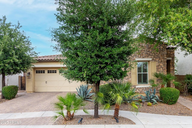 4519 N 29th Way, Phoenix, AZ 85016 - view of property hidden behind natural elements with stone siding, decorative driveway, a garage, and stucco siding