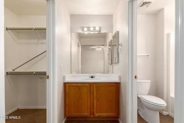 9332 W Mary Ann Dr, Peoria, AZ 85382 - full bathroom featuring vanity, a walk in closet, toilet, baseboards, and tile patterned flooring