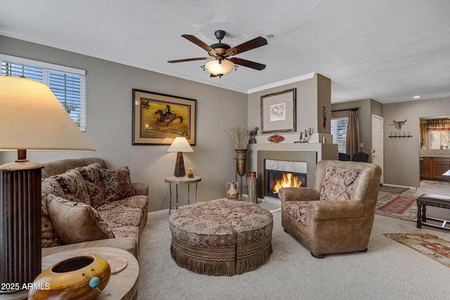 living room featuring crown molding, plenty of natural light, ceiling fan, and carpet