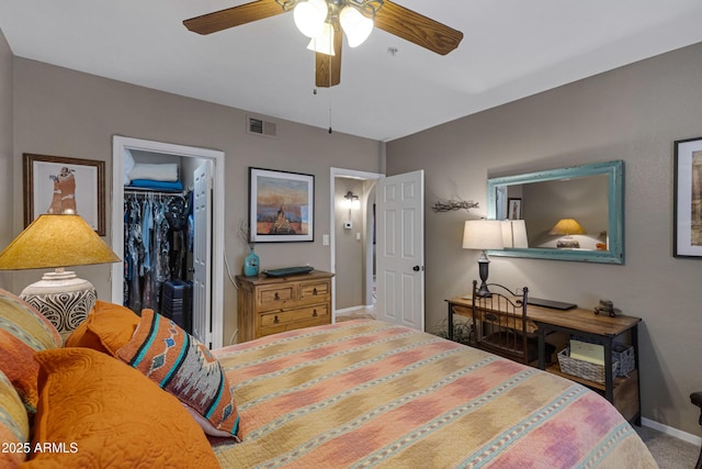 bedroom featuring carpet flooring, a spacious closet, ceiling fan, and a closet