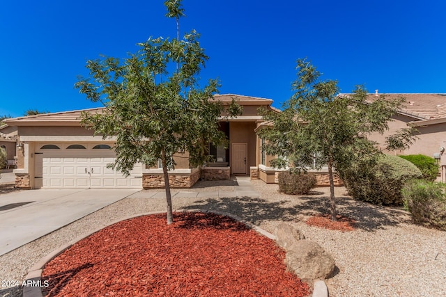 view of front of property with a garage, driveway, stone siding, and stucco siding