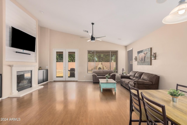 living room with lofted ceiling, a large fireplace, wood finished floors, visible vents, and french doors