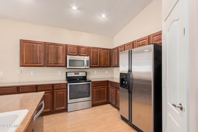 kitchen featuring recessed lighting, light countertops, appliances with stainless steel finishes, a sink, and light wood-type flooring