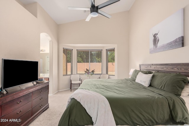 bedroom with baseboards, arched walkways, a ceiling fan, light colored carpet, and vaulted ceiling