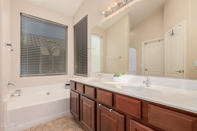 full bath with a garden tub, a sink, and double vanity