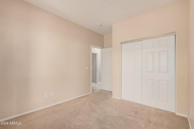 unfurnished bedroom with carpet, baseboards, and a closet