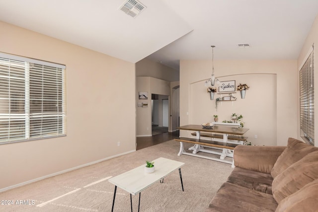 living area with vaulted ceiling, carpet floors, visible vents, and baseboards