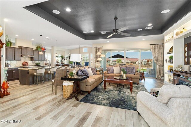 living room with ceiling fan, light hardwood / wood-style flooring, and plenty of natural light