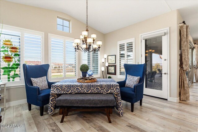 interior space with an inviting chandelier, lofted ceiling, and light hardwood / wood-style floors