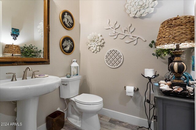 bathroom featuring hardwood / wood-style flooring and toilet