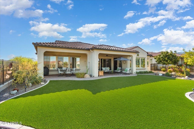 rear view of house with a patio, a yard, and ceiling fan