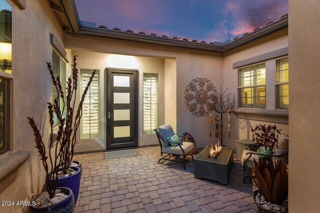 exterior entry at dusk featuring a patio area