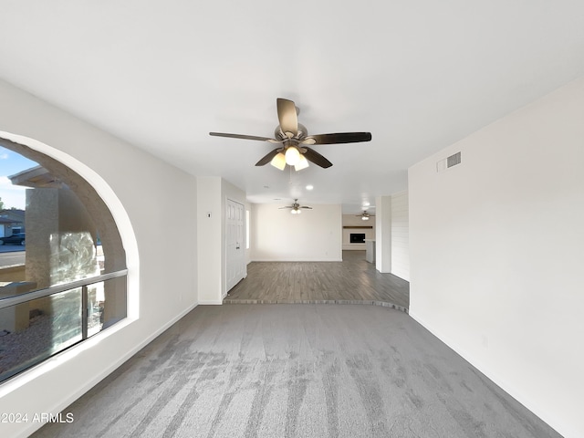 unfurnished living room featuring ceiling fan and hardwood / wood-style flooring