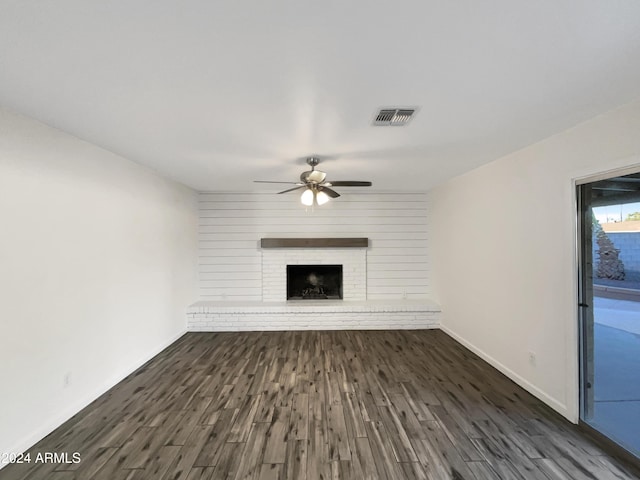 unfurnished living room featuring dark hardwood / wood-style floors, ceiling fan, and a fireplace