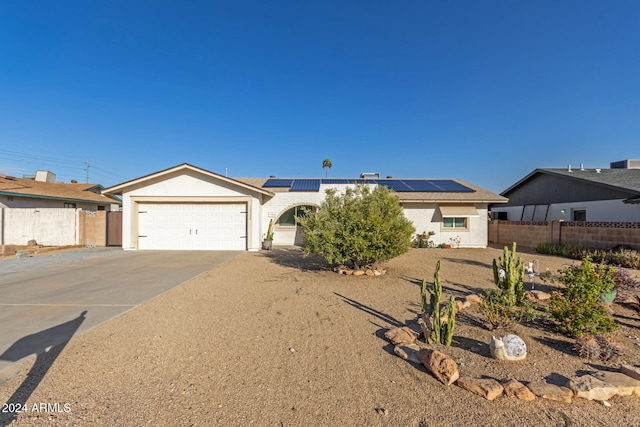 ranch-style house with solar panels and a garage