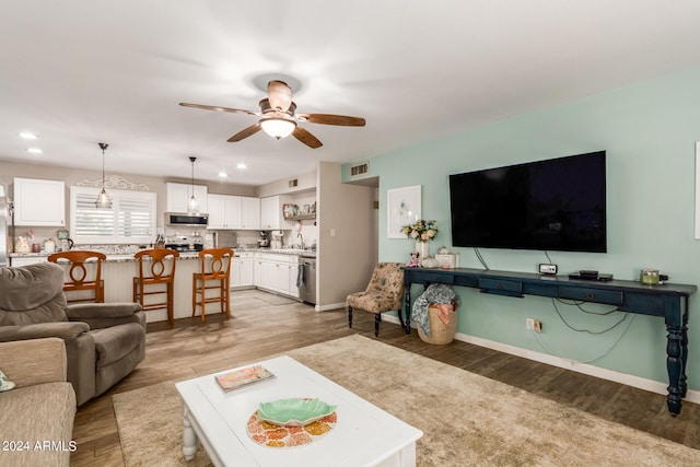 living room with light wood-type flooring and ceiling fan