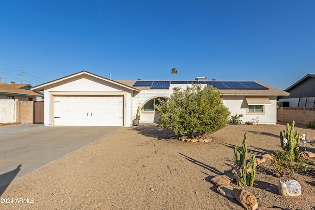 ranch-style house featuring solar panels and a garage