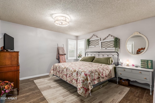 bedroom featuring dark wood-type flooring and a textured ceiling