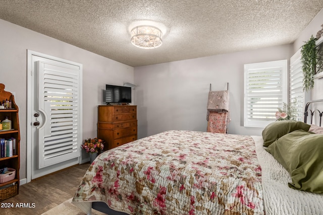 bedroom with hardwood / wood-style floors and a textured ceiling