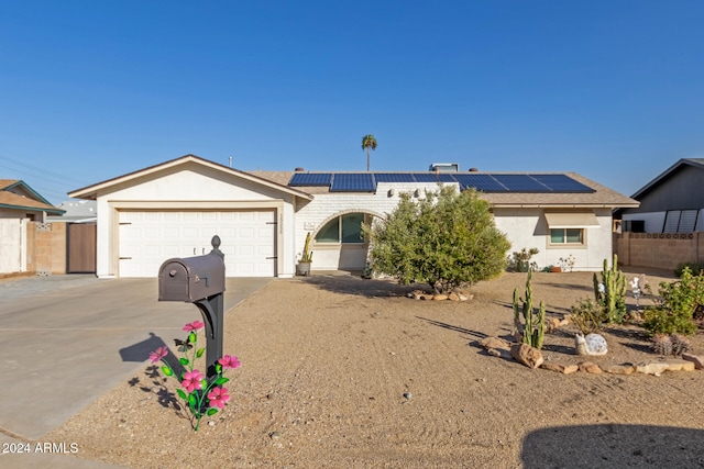 ranch-style home featuring solar panels and a garage