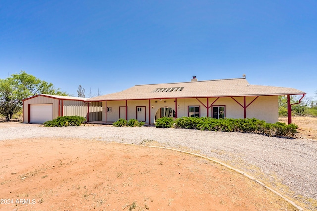 view of front of house featuring a garage and an outbuilding