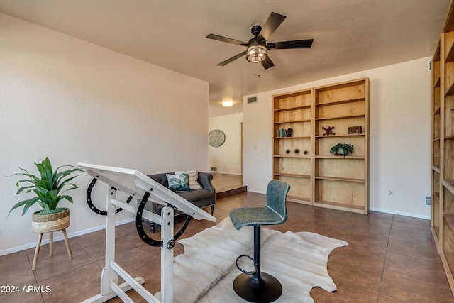 workout area featuring dark tile patterned floors and ceiling fan