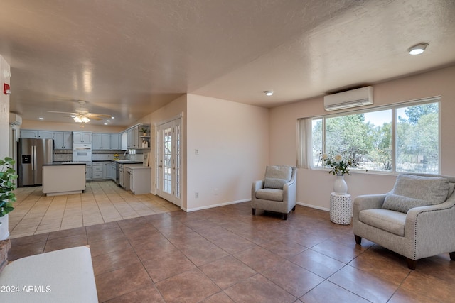 living area featuring ceiling fan, tile patterned floors, a wall mounted air conditioner, and sink