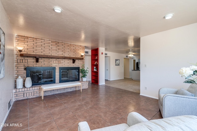 living room featuring ceiling fan, tile patterned flooring, and a brick fireplace