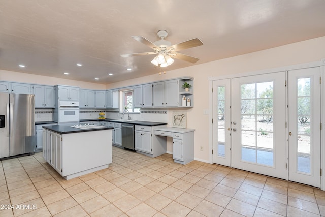 kitchen featuring appliances with stainless steel finishes, a center island, decorative backsplash, and plenty of natural light