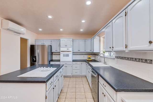 kitchen featuring sink, white cabinetry, stainless steel appliances, a center island, and an AC wall unit