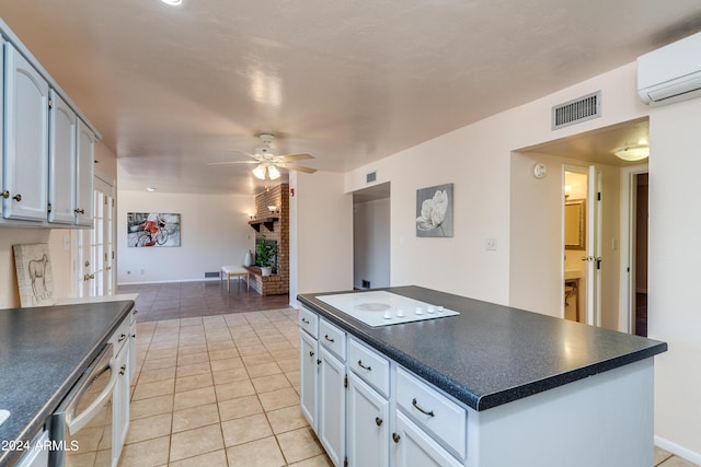 kitchen featuring light tile patterned floors, dishwasher, ceiling fan, white cabinetry, and a wall mounted AC