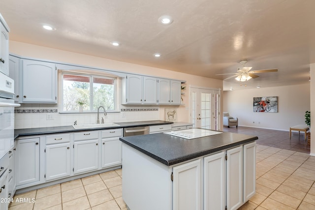 kitchen with sink, white appliances, white cabinets, and light tile patterned flooring