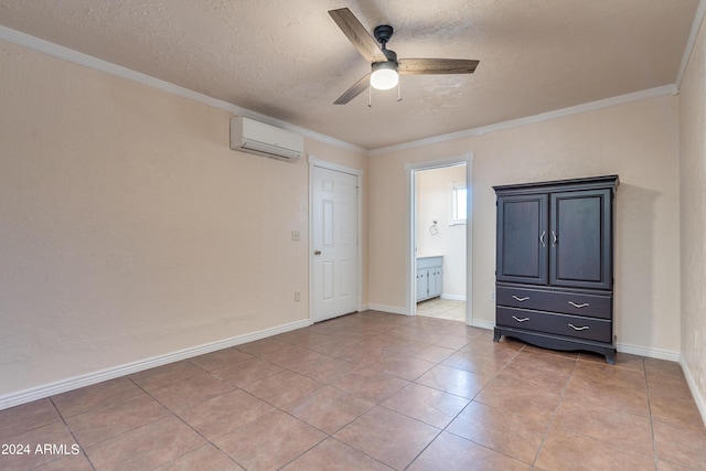 unfurnished bedroom with ensuite bathroom, a wall mounted air conditioner, ceiling fan, crown molding, and a textured ceiling