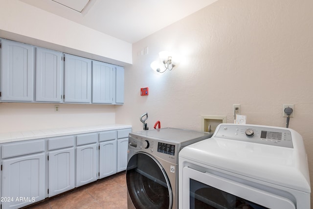 washroom with cabinets, independent washer and dryer, and light tile patterned flooring