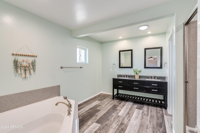 bathroom featuring hardwood / wood-style flooring, vanity, a bathtub, and beamed ceiling