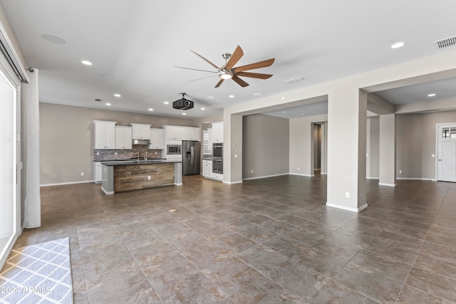 unfurnished living room featuring ceiling fan and sink