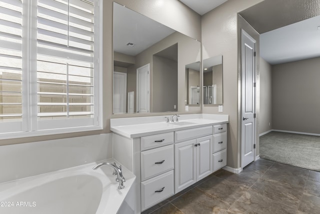 bathroom with visible vents, baseboards, vanity, and a garden tub