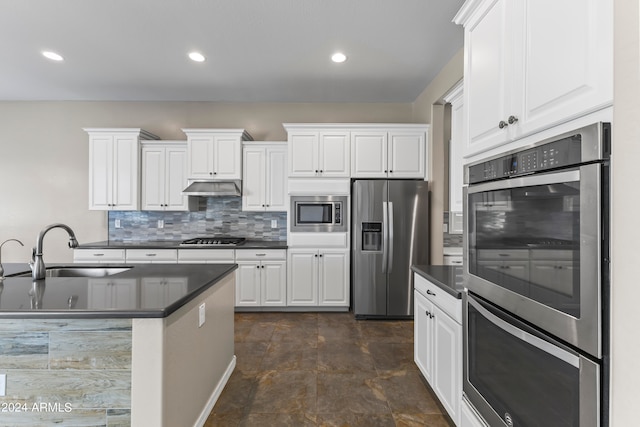 kitchen with white cabinets, appliances with stainless steel finishes, backsplash, and sink