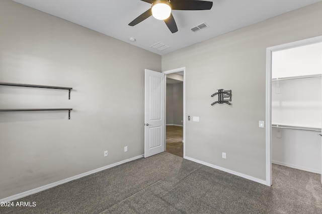 unfurnished bedroom featuring a spacious closet, visible vents, baseboards, and carpet floors
