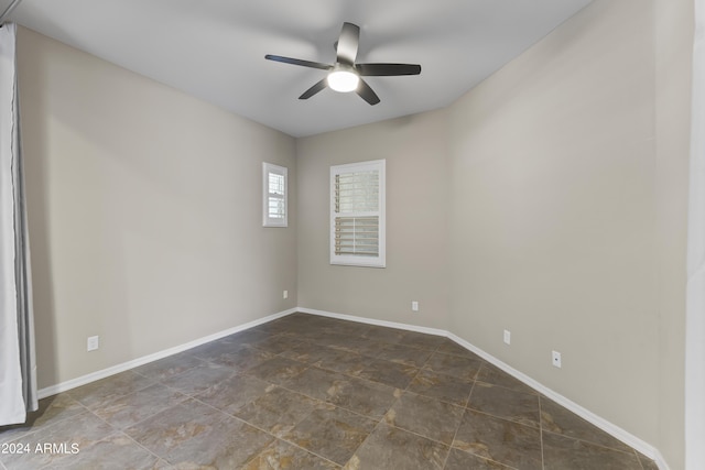 unfurnished room with baseboards and a ceiling fan
