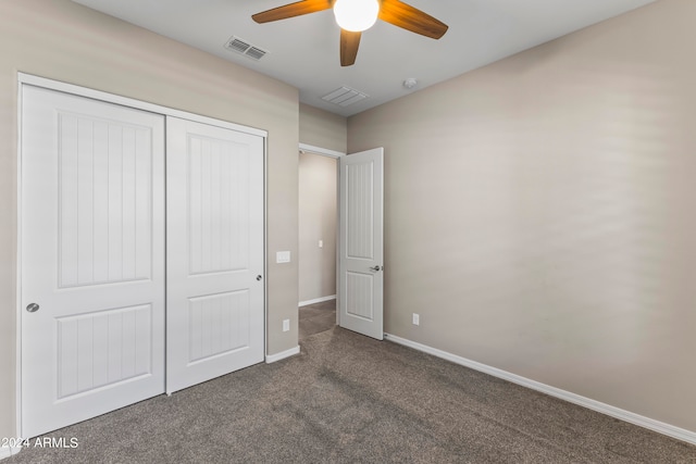 unfurnished bedroom with dark carpet, a closet, and ceiling fan