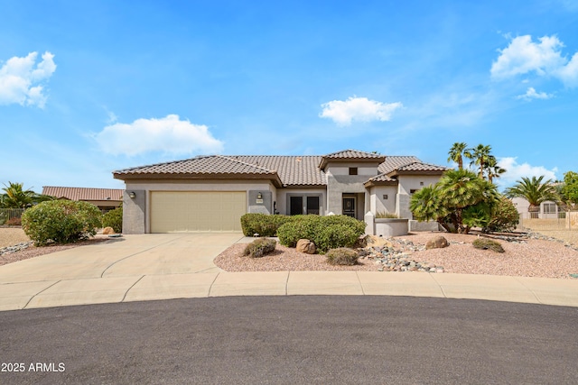 mediterranean / spanish-style home with stucco siding, concrete driveway, an attached garage, and a tile roof