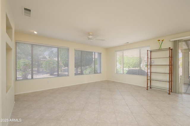 unfurnished room with light tile patterned floors, visible vents, baseboards, and a ceiling fan