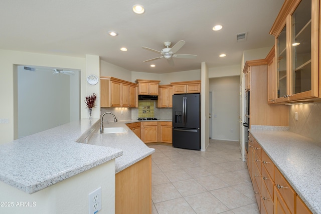 kitchen with a sink, ceiling fan, visible vents, and black fridge