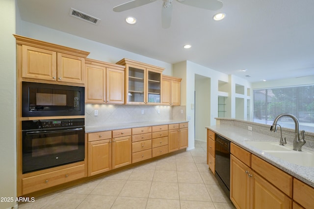 kitchen with visible vents, black appliances, a sink, backsplash, and ceiling fan